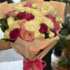 Bouquet of pink, cream, and white roses wrapped in peach paper