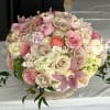 Large pastel bouquet of roses, orchids, and hydrangeas in a low vase