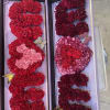 Two open gift boxes filled with red and pink carnation letters