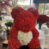 Red rose teddy bear with a white heart on a black base