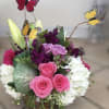 Pink roses and white hydrangeas with butterfly picks in a glass vase