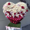 Heart-shaped rose arrangement in white, pink, and red with a pink ribbon