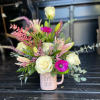 Pink mug vase with white roses, lilies, and a magenta anemone