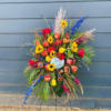 Tall colorful floral standing spray on a metal easel