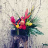 This is a tropical floral arrangement with black rock accents, is created