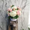 A well rounded array of white hydrangeas and pink roses, densely packed