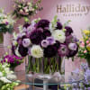 A stunning floral arrangement featuring a cube-shaped clear vase filled with a