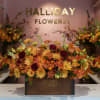 A beautifully arranged autumn flower display The centerpiece is a rustic, brown
wooden