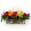 Colorful floral centerpiece with three white candles in a birch bark container