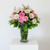 Pink and cream roses arranged in a clear glass vase