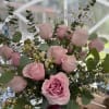 Pink rose birthday arrangement with filler flowers in a pink vase and a Happy Birthday pick.