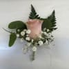Pink rose boutonniere with white baby's breath and greenery