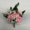 Pink floral bouquet with small white filler flowers and dark green leaves