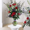 Tall bouquet of red, white, and purple flowers in a glass vase