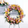 Circular wreath of pastel roses on a black stand