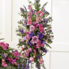 Tall arrangement of pink and purple flowers on a stand