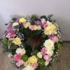 Heart-shaped floral wreath with pink, yellow, and white flowers