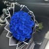 Bouquet of vivid blue roses wrapped in black and white paper
