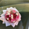 Bouquet of pink, red, and white roses wrapped in pale paper