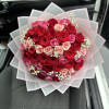 Bouquet of red and pink roses wrapped in translucent paper
