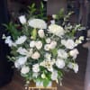 White floral arrangement with roses, chrysanthemums, and lilies in a vase