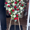 Heart-shaped floral wreath of red and white roses on a wooden easel