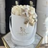 Cream roses in a white round box with a small angel ornament.