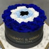 Round box of blue, white, and light blue roses with a black center rose