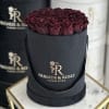 Box of deep burgundy roses in a black round hatbox