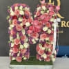 Large floral letter M covered in pink, white, and purple roses