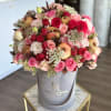 Pink and red rose bouquet in a gray hatbox with pomegranates