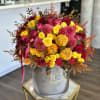 Bouquet of red and yellow roses with pink dahlias in a gray hatbox