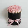 Pink roses arranged in a black round box with a pink ribbon