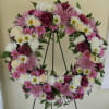 Pink and white floral wreath on a black easel