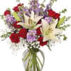Bouquet of red roses and white lilies in a clear glass vase