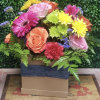 Colorful mixed bouquet in a square box with roses, gerberas, and mums