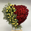 Heart-shaped arrangement of red and yellow roses on an easel