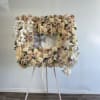 Floral standing easel with white orchids and blush roses around a framed tribute