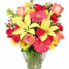 Colorful bouquet of roses, gerbera daisies, and lilies in a glass vase