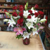 Red roses and white lilies arranged in a glass vase