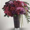Bouquet of pink and purple roses in a tall dark vase