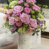Pink roses and mixed blooms arranged in a white pitcher vase