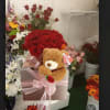 Red rose bouquet in a pink gift box with a teddy bear