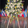 Large standing floral spray with white lilies, yellow roses, and purple flowers