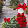 Clear gift bag holding red roses with red bows