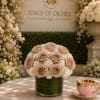 A compact cluster of blush roses and delicate white filler blooms creates