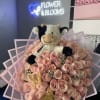 Pink rose bouquet with a plush cow topper and pink wrap