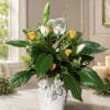 White and yellow floral arrangement in a white basket