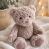 Plush teddy bear sitting on a knitted blanket