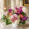 Pink and purple floral arrangement in a white vase